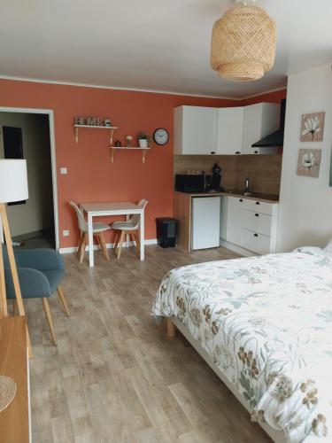 una camera da letto con un letto, un tavolo e una cucina di superbe grand studio tout confort avec exterieur a Poussan