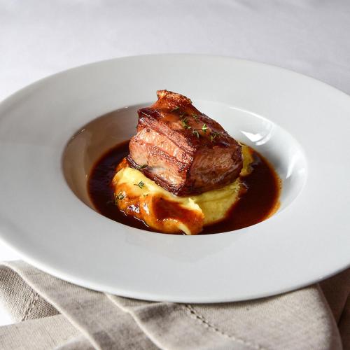 a plate of food with a piece of meat in a sauce at Penzion Ovečka in Nýdek