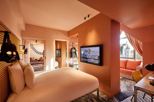 a bedroom with a large bed and a living room at Mama Shelter Dijon in Dijon