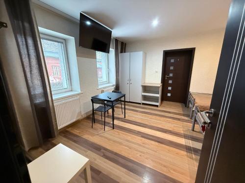 a living room with a table and a refrigerator at Noclegi Lebud-bis in Starachowice