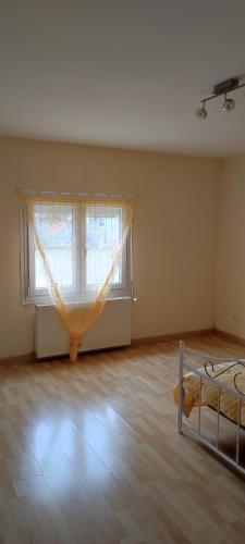 an empty room with a bed and a window at appartement indépendant privé in Mathay