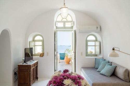 a living room with a couch and a tv at Nano Oia Villas in Oia