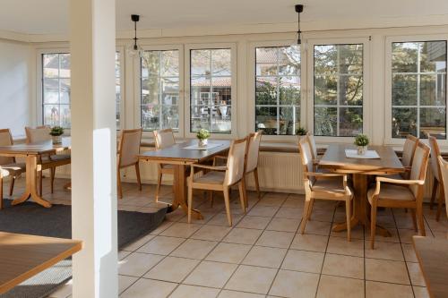 a restaurant with tables and chairs and windows at The Resting Place in Lemgo