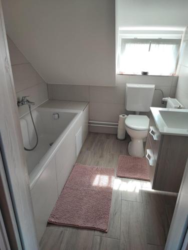 a bathroom with a tub and a toilet and a sink at Aminyaralónk in Balatonmáriafürdő
