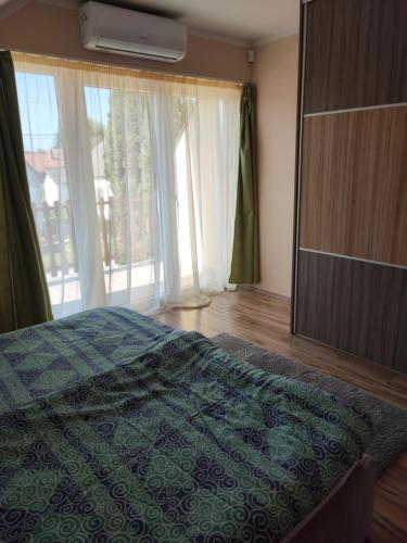 a bedroom with a bed and a large window at Aminyaralónk in Balatonmáriafürdő