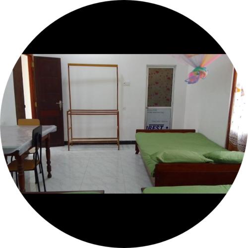 a room with two beds and a table and a table and a tableablish at Dinesh holidy resort in Kataragama