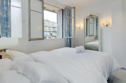 - une chambre blanche avec 2 lits et un miroir dans l'établissement Sunny Corner, à Nice