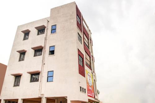 a tall white building with a sign on it at Hotel O Elite Inn in Nagpur