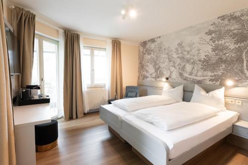 a bedroom with a white bed with a painting on the wall at Boutiquehotel Drei Ringe Schwörstadt - Rheinfelden in Schwörstadt