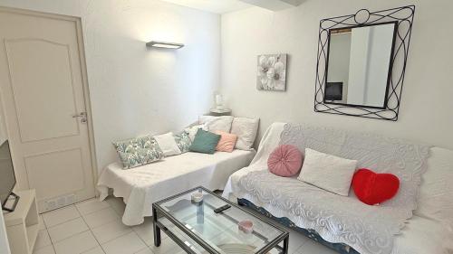 - un salon avec un canapé blanc et un miroir dans l'établissement Massilia 18, à Sainte-Maxime