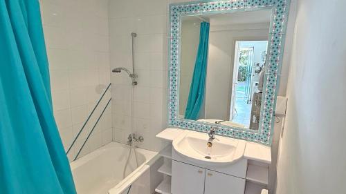 une salle de bain avec un lavabo, un miroir et une baignoire dans l'établissement Massilia 18, à Sainte-Maxime