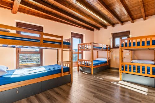 a room with three bunk beds in it at Albergue El Colmado in Breceña
