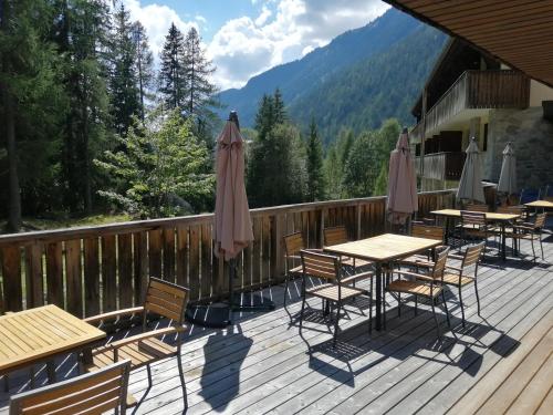 une terrasse avec des tables, des chaises et des parasols dans l'établissement Chalet ATC Routes du Monde Argentiere-Chamonix, à Chamonix-Mont-Blanc