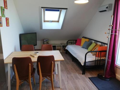 une pièce avec une table, des chaises et un lit dans l'établissement Gîte Les Anes de Medeina, à Ingrannes