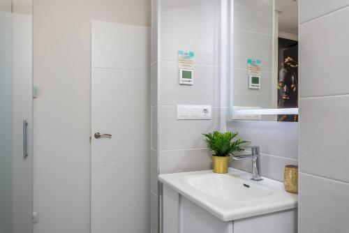 a white bathroom with a sink and a shower at La Zenia Cocoon Lux Penthouse in Dehesa de Campoamor
