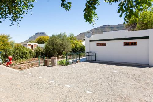 a white building with mountains in the background at 4 Rothman Street B&B in Graaff-Reinet