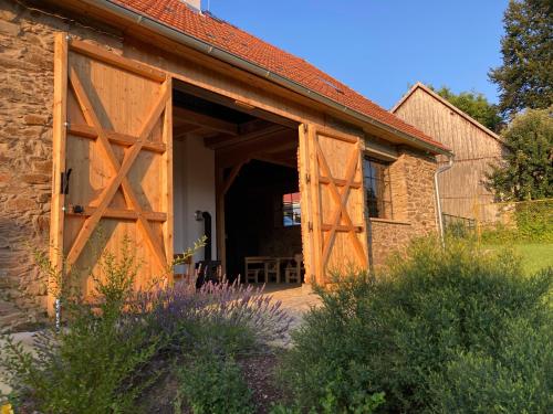 a barn with a large wooden door in a yard at Stodola 63 in Pacov