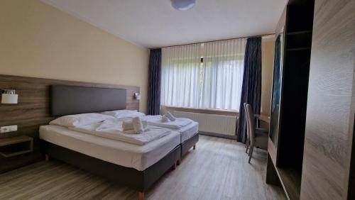 a bedroom with a bed and a window at Hotel Tini in Bad Fallingbostel
