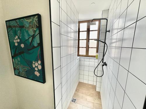 La salle de bains est pourvue d'une douche et d'une peinture murale. dans l'établissement Appart 2 chambres HYPERCENTRE de Berck-Plage - WIFI, à Berck-sur-Mer