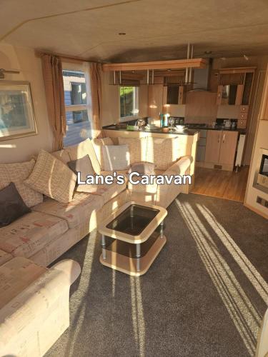 a living room with a couch and a kitchen at Southview holiday park caravan in Skegness