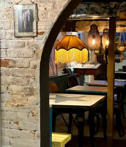 a restaurant with tables and chairs and a brick wall at The Bridge House in Bridport