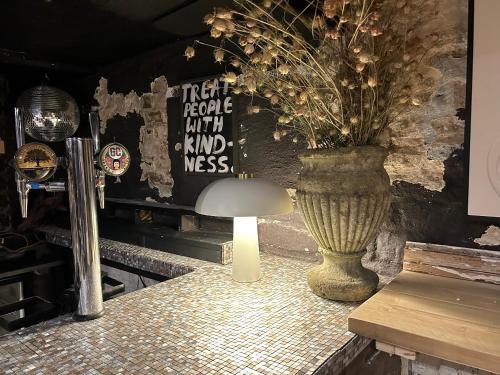 a table with a vase and a lamp on it at The Bridge House in Bridport