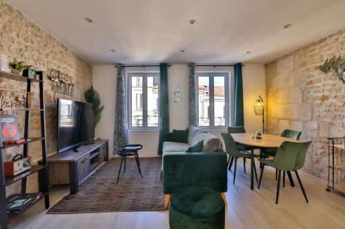 un salon avec une table et un canapé dans l'établissement LE LUCIEN Eco-Appart'Hôtel - Angouleme - Centre - Wifi - Parking privé - Classé 4 étoiles, à Angoulême