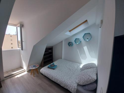 een kleine slaapkamer met een bed op zolder bij Centre de Nice : Studio rénové, climatisé et calme in Nice