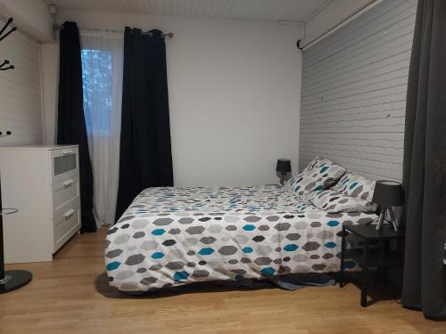 a bedroom with a bed with a comforter and a window at L'esquiróu in Rocbaron