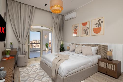 a bedroom with a large bed and a balcony at Marina 7 Resort By Seven Seasons in El Alamein