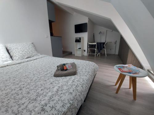 een slaapkamer met een bed, een tafel en een trap bij Centre de Nice : Studio rénové, climatisé et calme in Nice
