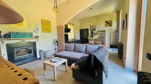 a living room with a couch and a fireplace at Curt da Beta - Casa vacanze con giardino, in Corte del XVIII secolo in Malnate