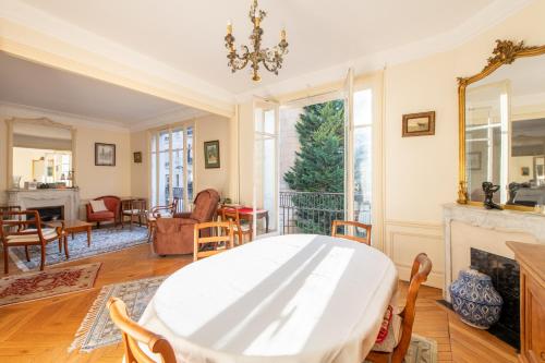 un salon avec une table et une cheminée dans l'établissement Francisque Sarcey - Appartement proche Trocadéro, à Paris