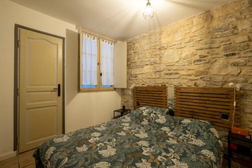une chambre avec un lit et un mur en pierre dans l'établissement The Bayonnais moment - Cosy T2 in the heart of Bayonne, à Bayonne