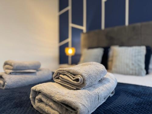 a pile of towels sitting on top of a bed at Modern 2 Bedroom Home In Central Location with 3 Beds and Free Driveway Parking in Doncaster