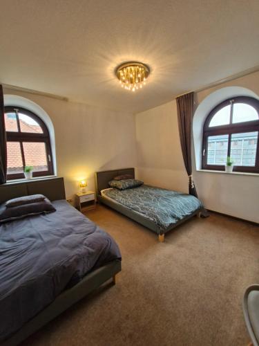 a bedroom with two beds and two windows at Stadtvilla Zimmervermietung in Heidenheim