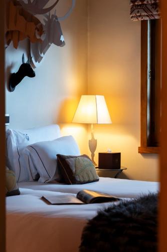 a bedroom with a bed with a lamp on it at Alpes Hôtel du Pralong in Courchevel
