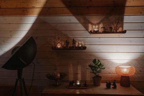 a room with a table with a lamp and a wall at Kisvacok tiny house in Kismaros
