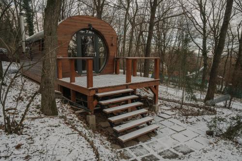 a wooden play structure with stairs in the snow at Kisvacok tiny house in Kismaros