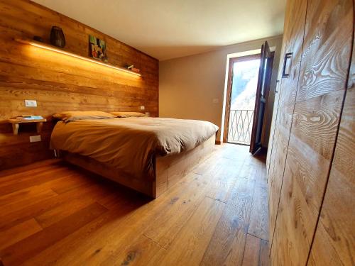 a bedroom with a bed and a wooden wall at Casa dello Gnomo in Rossa