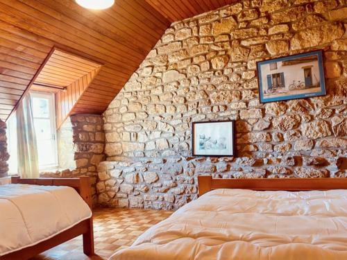 une chambre avec un mur en pierre et un lit dans l'établissement Maison accueillante à Erdeven avec jardin, à Erdeven