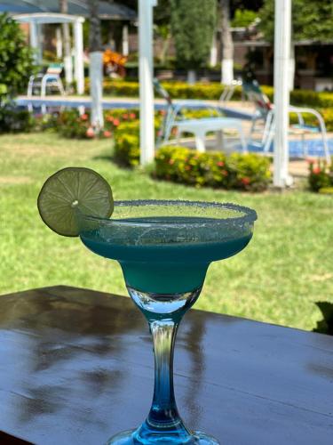 a blue drink with a lime on top of a table at Hotel Campestre La María Toro Valle in Toro
