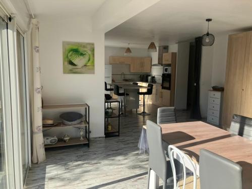 une salle à manger et une cuisine avec une table et des chaises dans l'établissement Villa plain-pied tout confort 3 chambres avec jardin proche des plages, à Vias