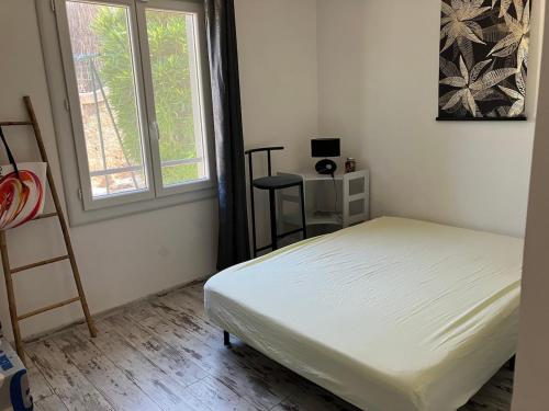 une petite chambre avec un lit et une fenêtre dans l'établissement Villa plain-pied tout confort 3 chambres avec jardin proche des plages, à Vias