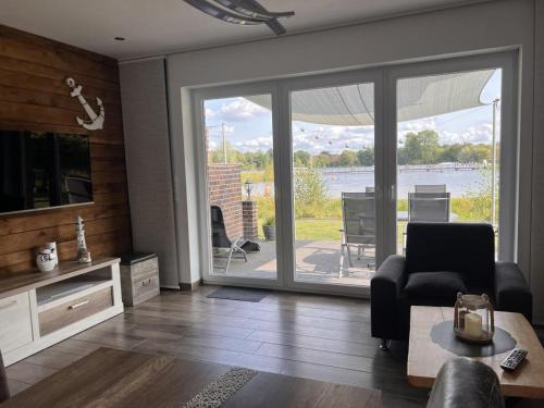 a living room with a large sliding glass door at NEU! Ferienhaus Schöne Aussicht direkte Strandlage in Aurich