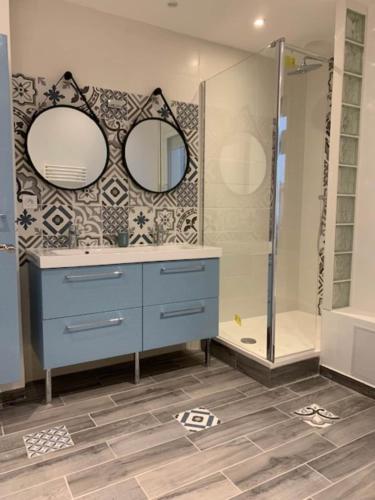 La salle de bains est pourvue d'une commode bleue et d'une douche. dans l'établissement Beau T3 180 degree sea view, à Palavas-les-Flots