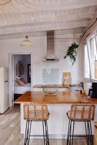 a kitchen with a wooden counter and two chairs at Siempre Feliz La Casita Escanfraga in Villaverde