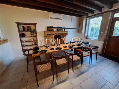 une salle à manger avec une table et des chaises et une cheminée dans l'établissement Ferme spacieuse climatisée, SPA & Pétanque, à Ruffey-lès-Beaune