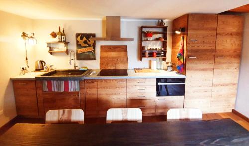 a kitchen with wooden cabinets and a table and chairs at Casa dello Gnomo in Rossa