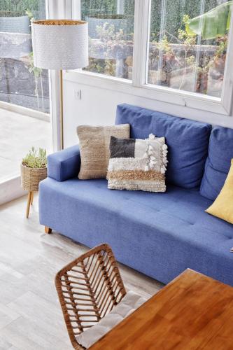 a blue couch with pillows on it in a living room at Siempre Feliz La Casita Escanfraga in Villaverde